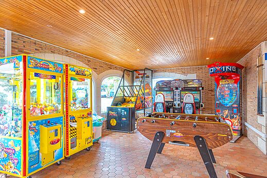 Speelzaal met arcadekasten, tafelvoetbal en basketbalspellen op camping CAPFUN Falaises in Gonneville sur Mer (14).