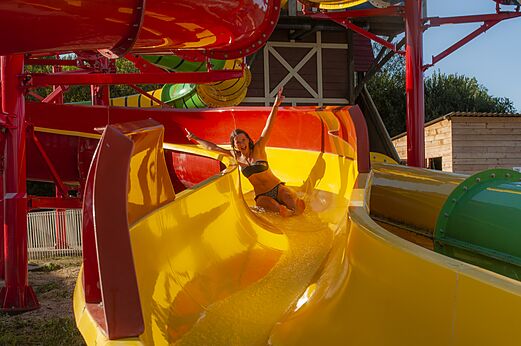 Vrouw op gele waterglijbaan bij CAPFUN Falaises in Gonneville sur Mer (14).