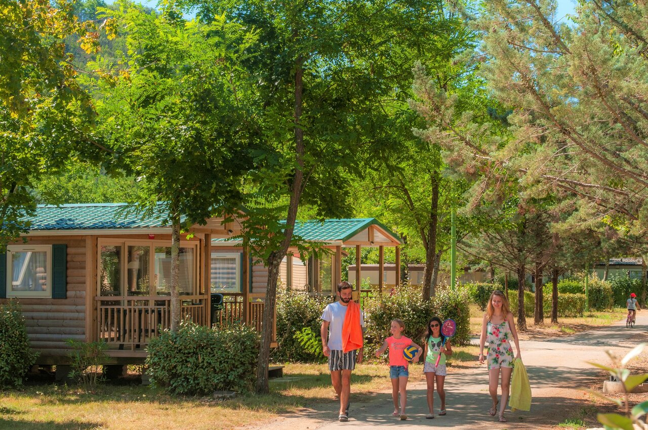 Familie wandelt langs stacaravans op camping CLICOCHIC Filament in Thoiras (30).