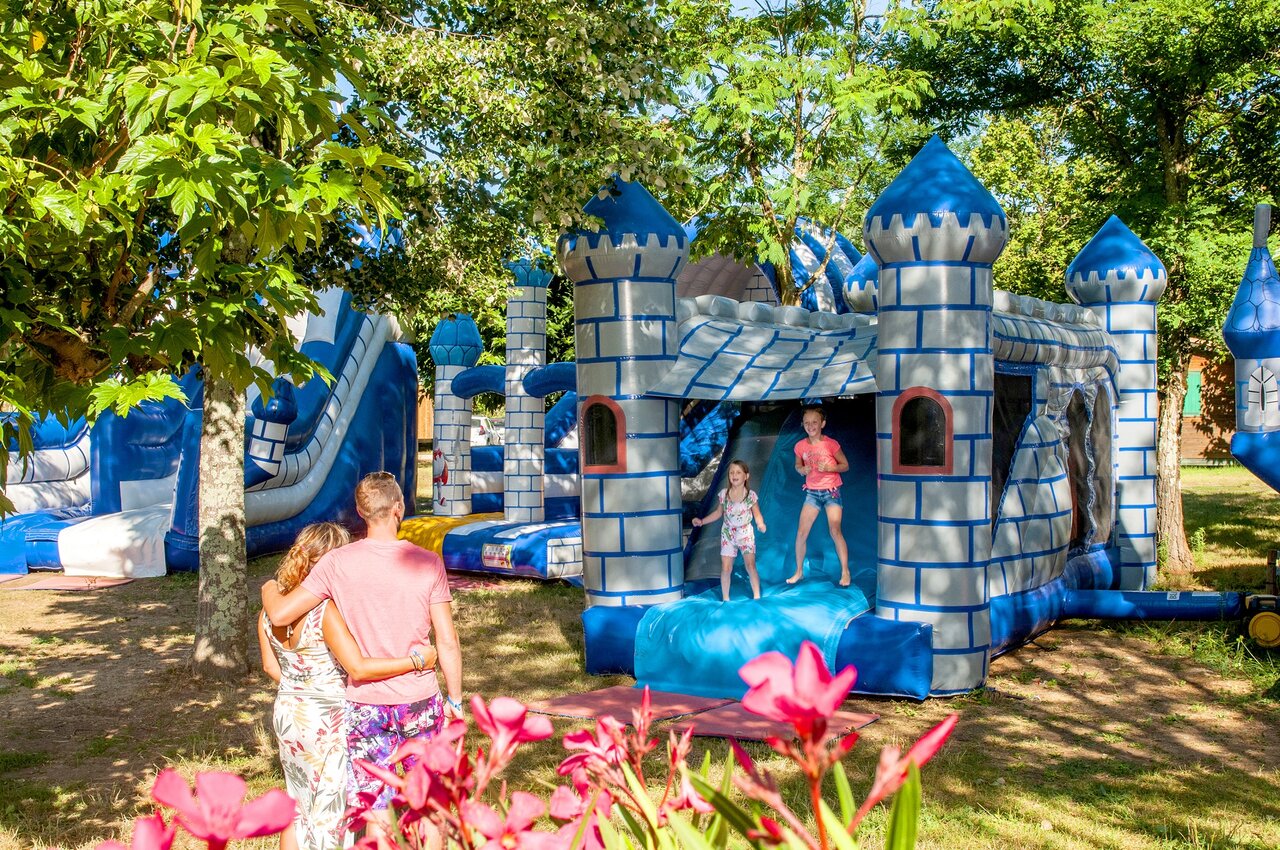 Opblaasbaar speelpark met kinderen en glijbanen op camping CLICOCHIC Filament in Thoiras (30).