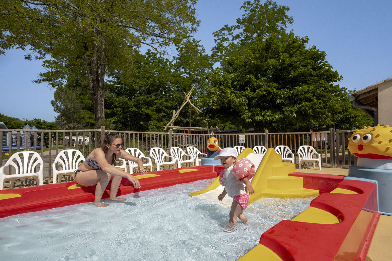 Kleurrijk kinderbad, glijbaan en waterspelen op camping CLICOCHIC Filament Thoiras.