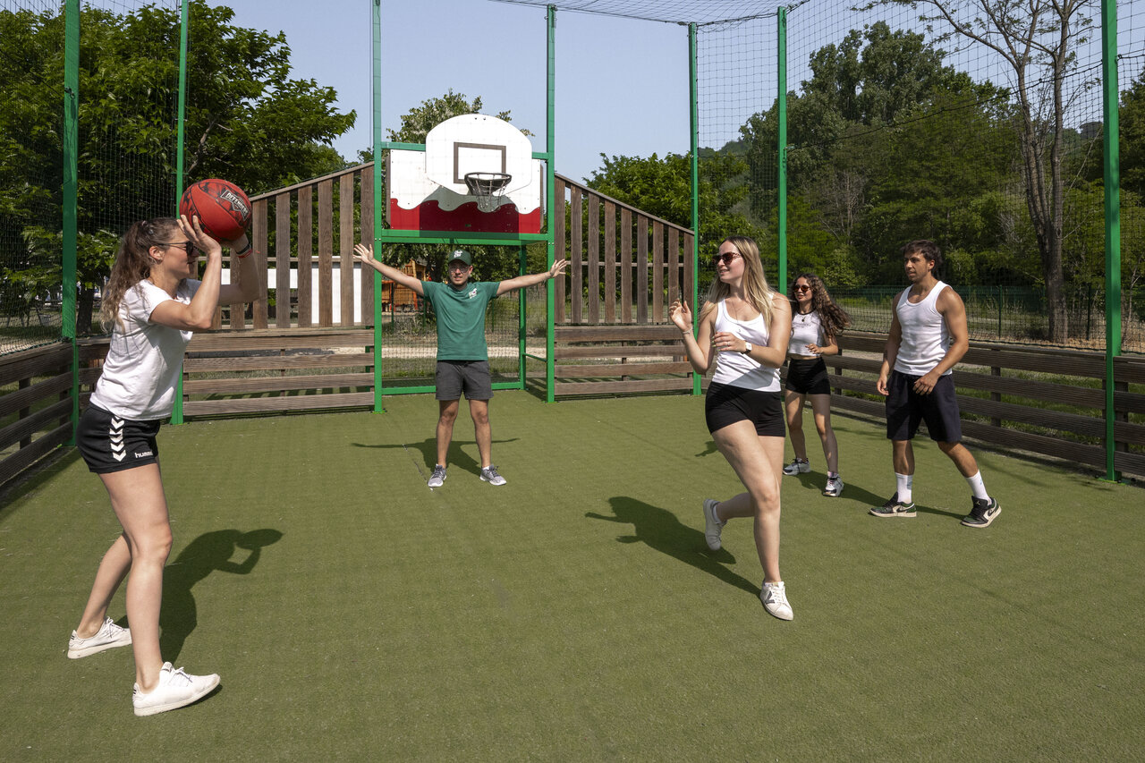Multisportterrein met jongeren die basketballen op camping CLICOCHIC Filament in Thoiras (30).