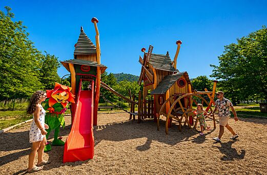 Houten speeltuin met glijbaan en mascotte op camping CLICOCHIC Filament in Thoiras (30).