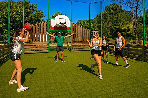 Multisportterrein met jongeren die basketballen op camping CLICOCHIC Filament in Thoiras (30).
