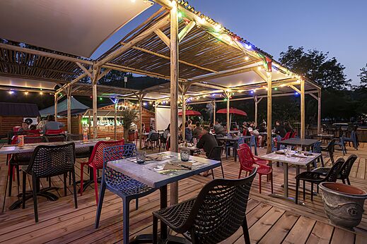 Levendig restaurant- en barterras 's avonds op camping CLICOCHIC Filament in Thoiras.