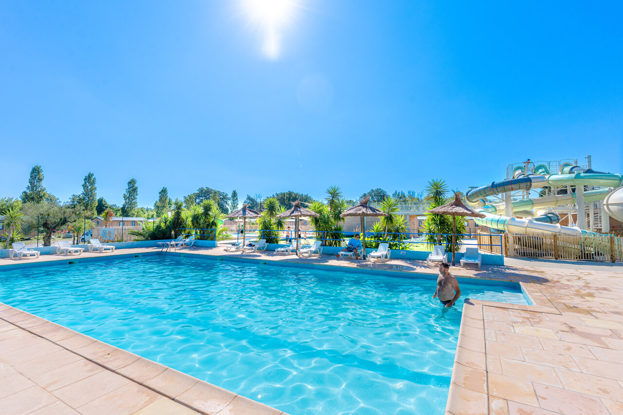Buitenzwembad met waterglijbanen en ligstoelen op camping VAGUES OCEANES Au Flamenco in Argel�s-sur-Mer (66).