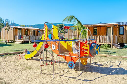 Kleurrijke speeltuin met glijbaan en kinderen op camping VAGUES OCEANES Au Flamenco in Argelès-sur-Mer (66).