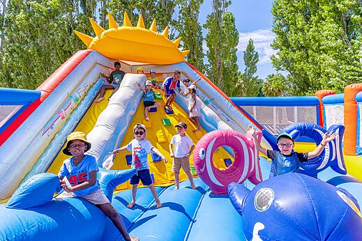 Kinderen spelen op een groot opblaasbaar kasteel met glijbaan op camping VAGUES OCEANES Au Flamenco in Argelès-sur-Mer (66).