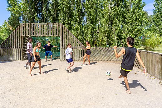Jongeren voetballen op het multisportterrein bij camping VAGUES OCEANES Au Flamenco in Argelès-sur-Mer (66).