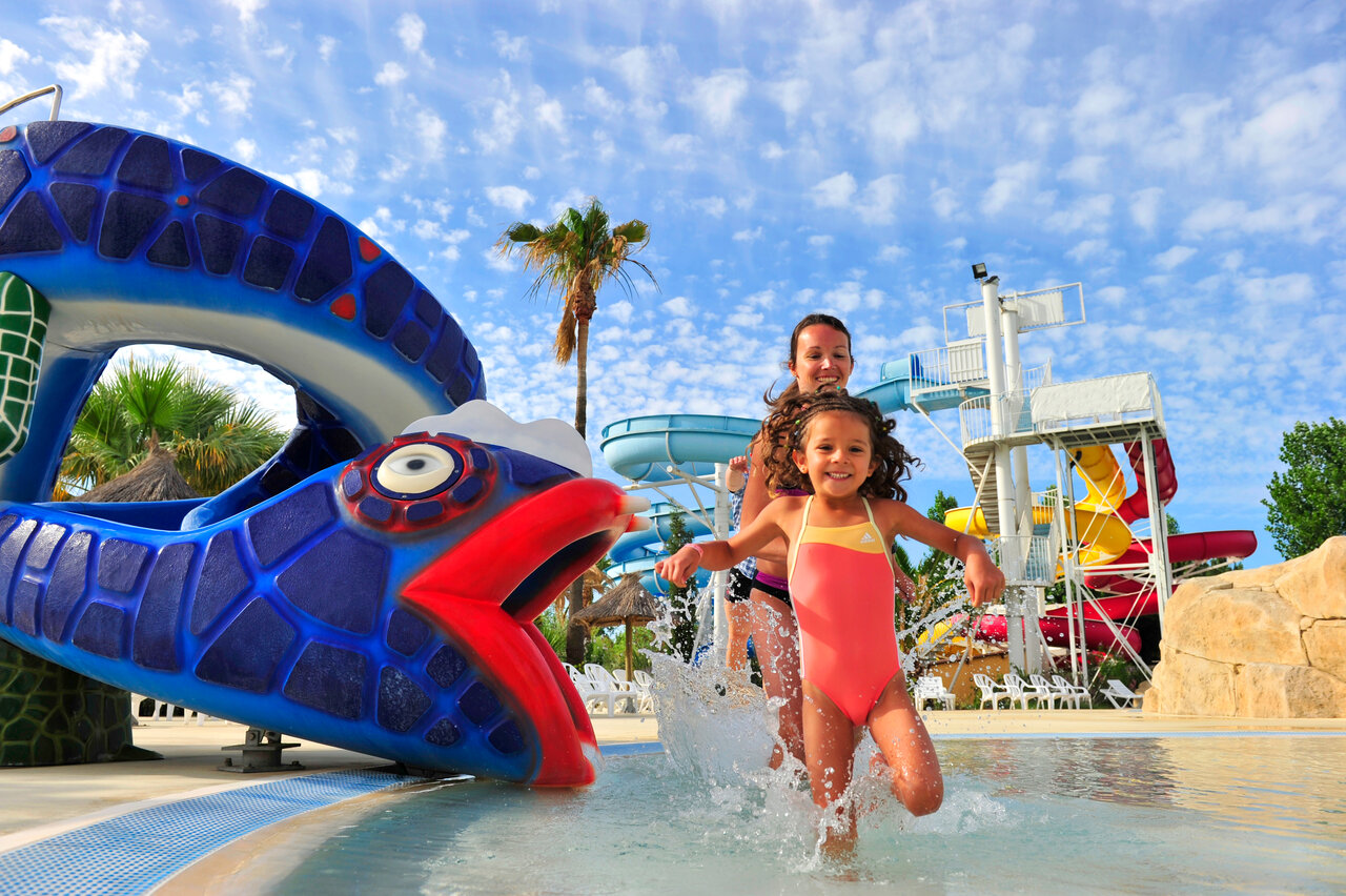 Visvormige glijbaan en waterspellen voor kinderen op camping CAPFUN Fleurs d'Agde, AGDE (34).
