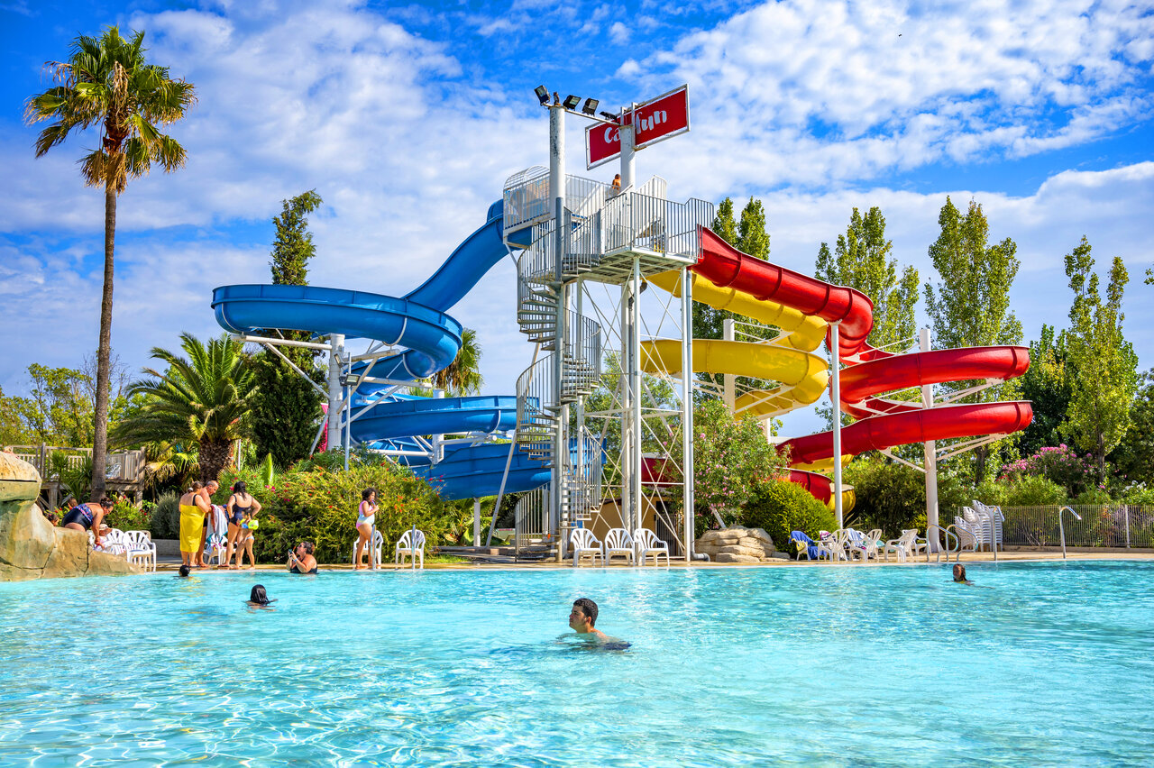 Buitenzwembad met kleurrijke glijbanen op camping CAPFUN Fleurs d'Agde in AGDE (34).
