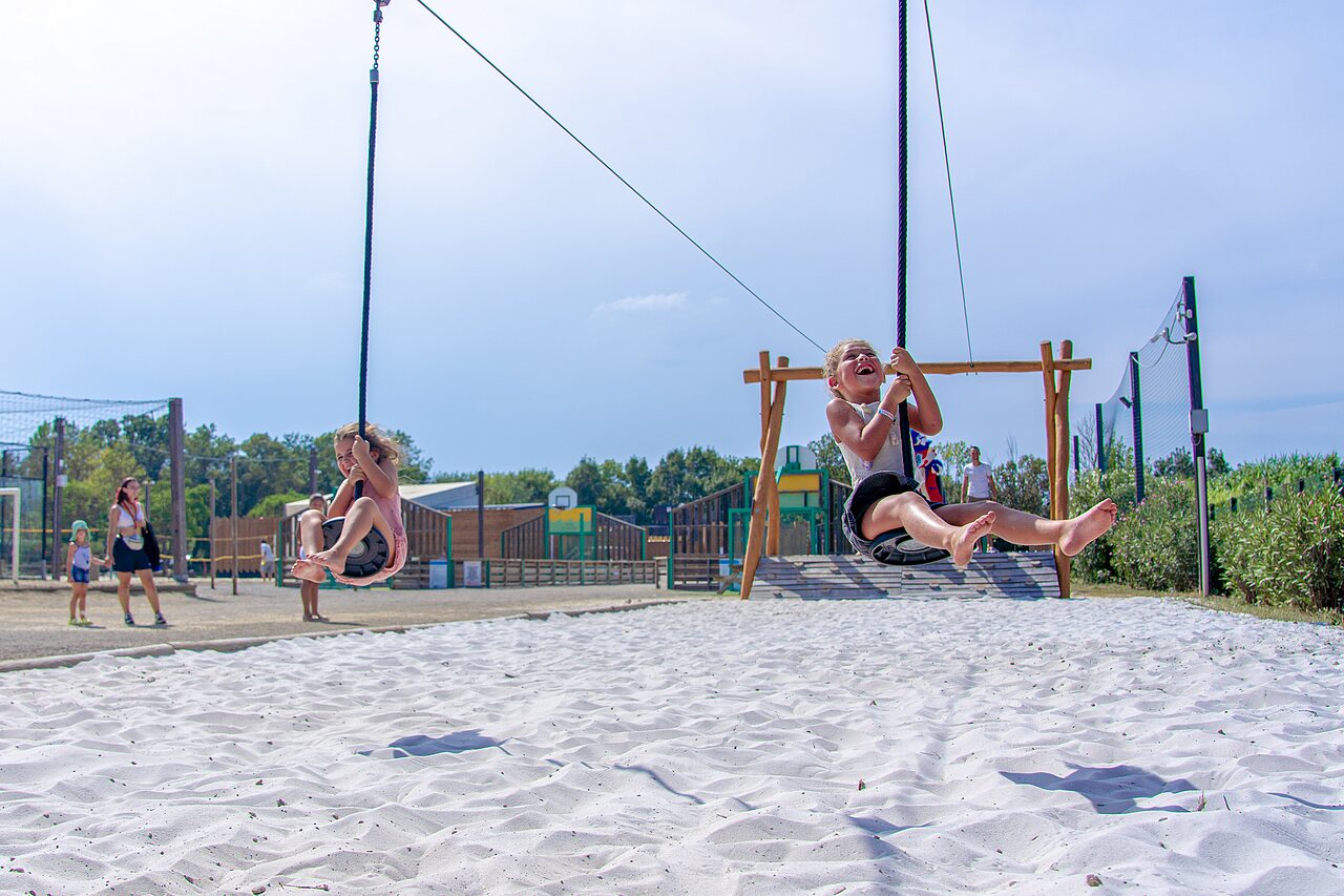 Blije kinderen op tokkelbanen boven zand bij CAPFUN Fleurs d'Agde in AGDE (34).