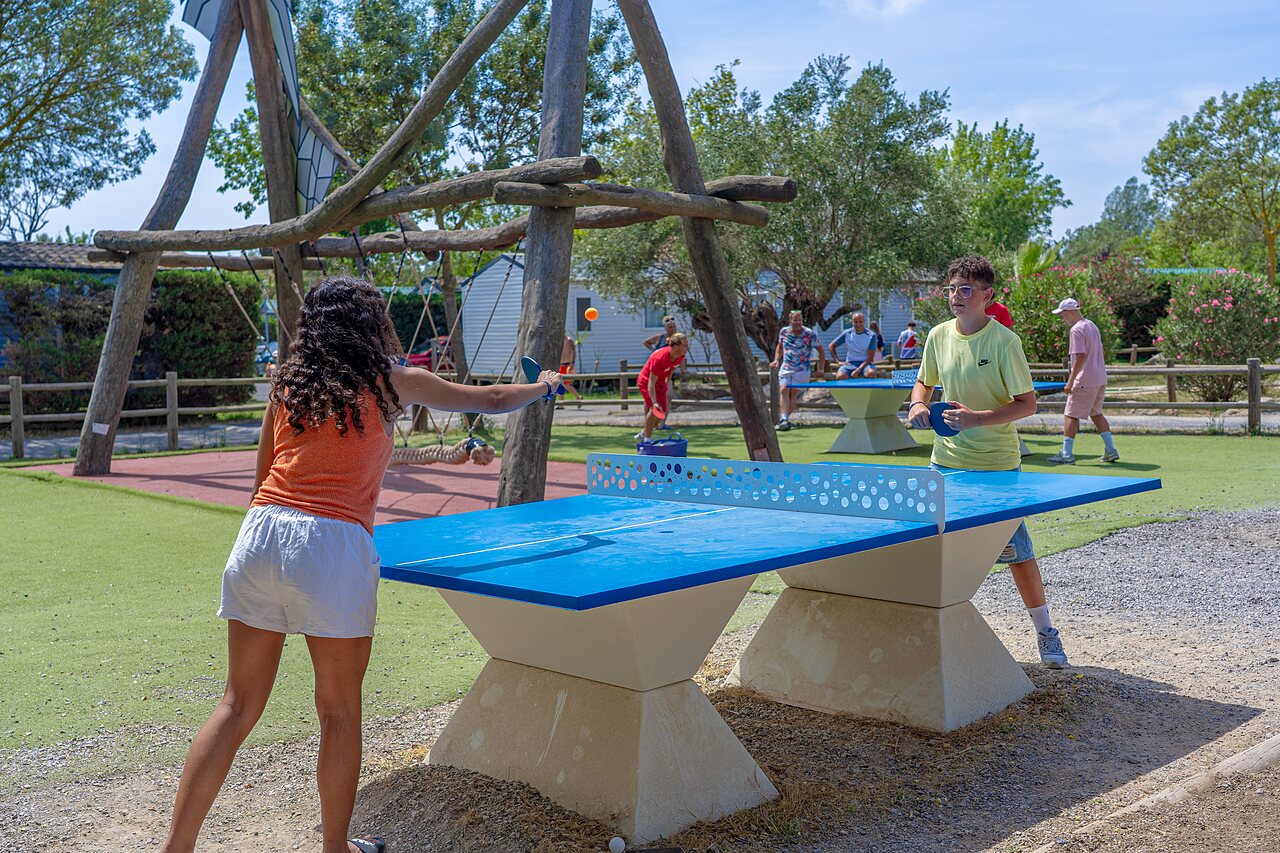 Jongeren spelen tafeltennis buiten op camping CAPFUN Fleurs d'Agde in AGDE.
