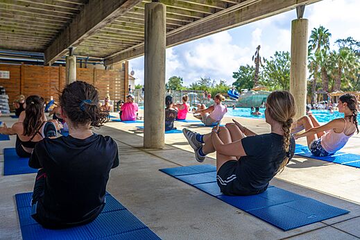 Groepsfitnessles onder afdak bij het zwembad op camping CAPFUN Fleurs d'Agde in AGDE (34).