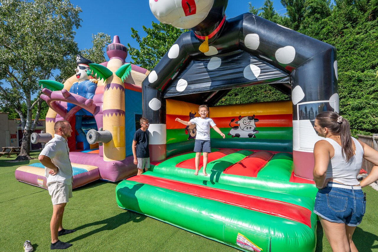 Kinderen vermaken zich op kleurrijke springkastelen op camping CAPFUN Fleur de Camargue (30).