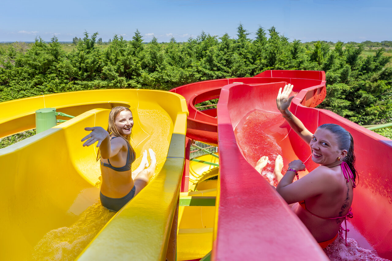 Twee lachende vrouwen op waterglijbanen op camping CAPFUN Fleur de Camargue in Saint-Laurent-d Aigouze.