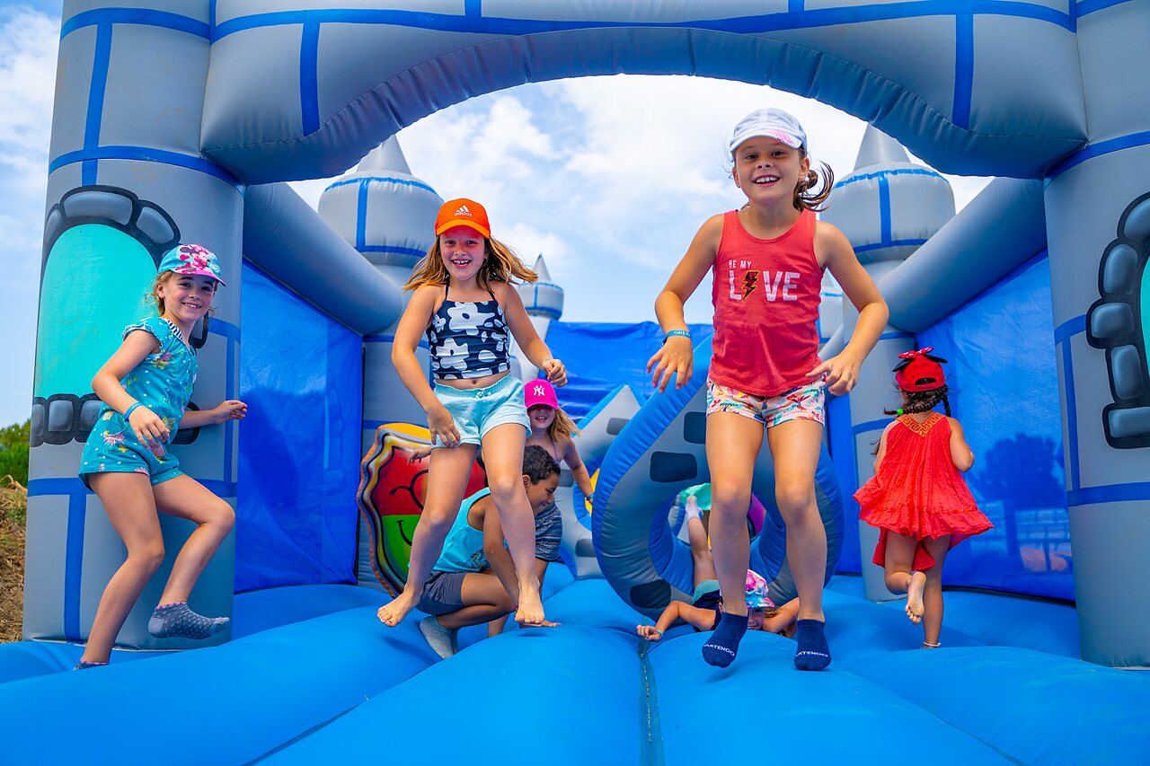 Opblaasbaar kasteel en kinderen spelend op camping CAPFUN Flots Bleus VIAS PLAGE (34).