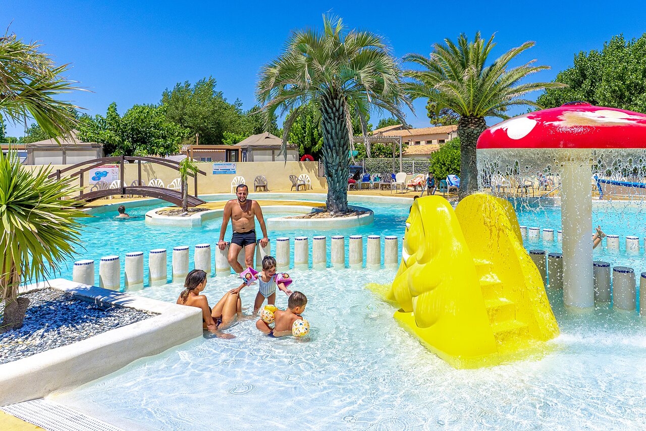 Buitenzwembad, gele glijbaan en spelletjes op camping CAPFUN Flots Bleus in VIAS PLAGE (34).