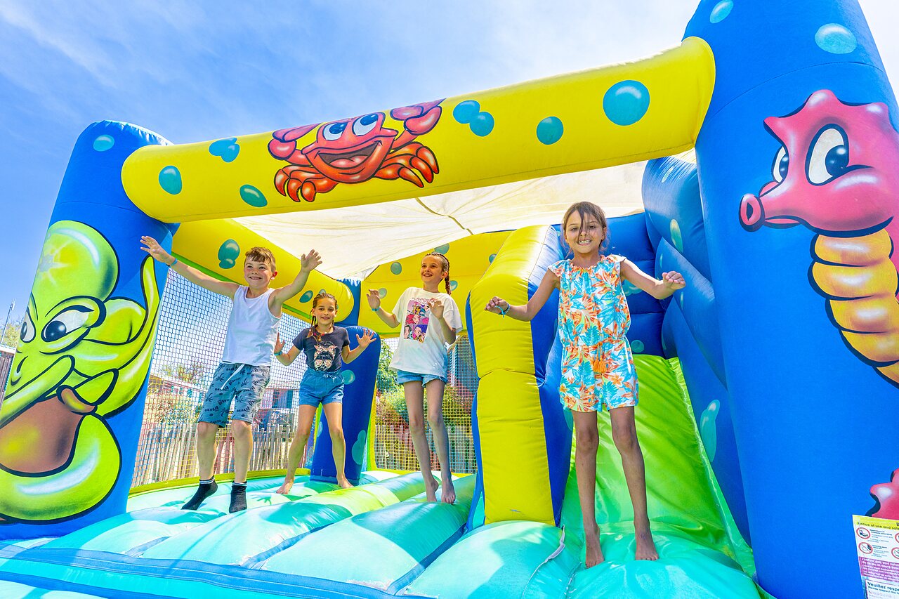 Kinderen vermaken zich op springkasteel op camping CAPFUN Flots Bleus in VIAS PLAGE (34).