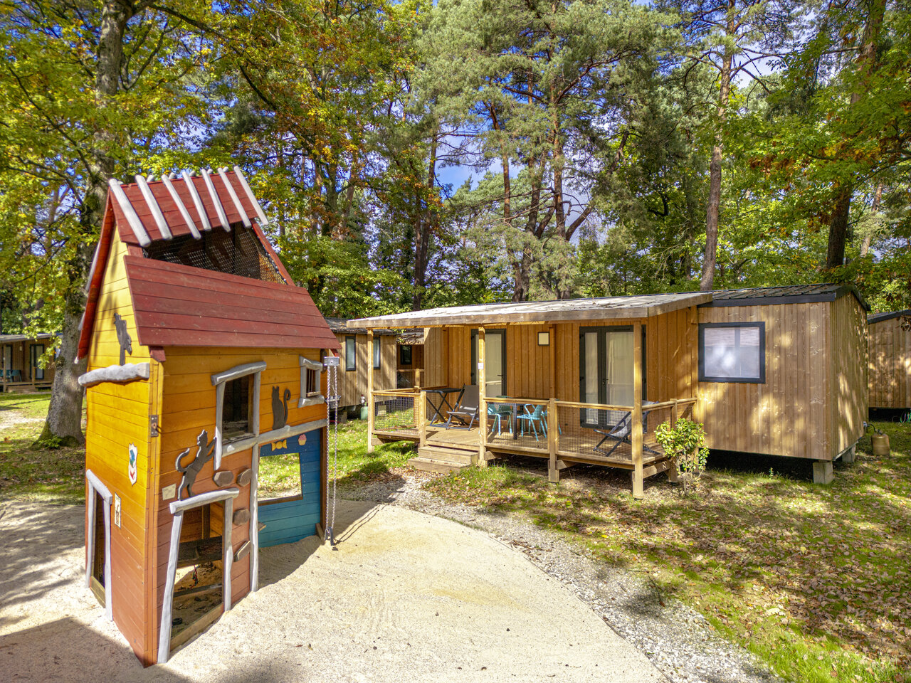 Houten speelhuis en stacaravans op camping CLICOCHIC La For�t d'Azal�e.
