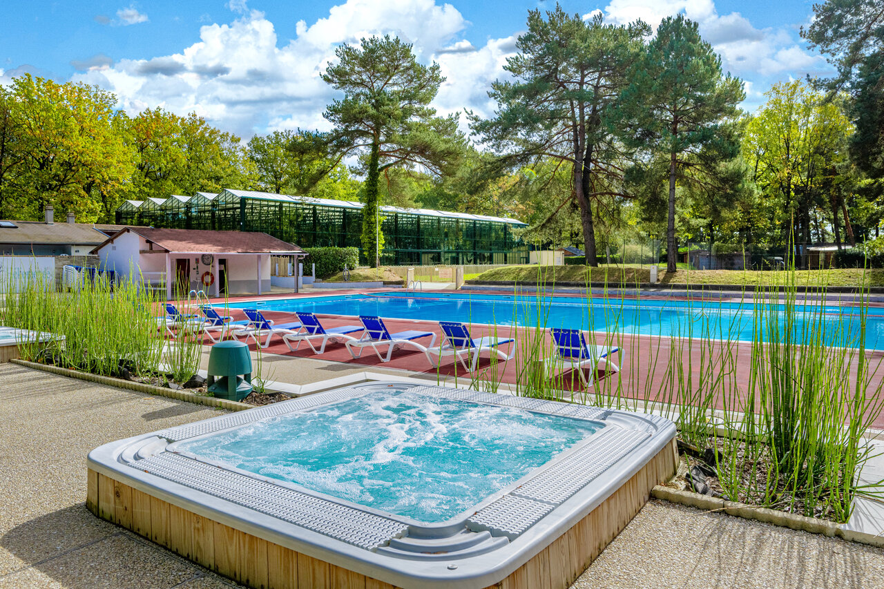 Jacuzzi, buitenzwembad, ligstoelen op camping CLICOCHIC La For�t d'Azal�e in Saint-Ch�ron (91).