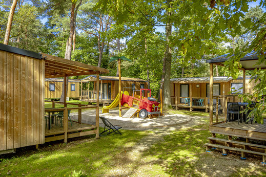 Houten stacaravans en speeltuin op camping CLICOCHIC La Forêt d'Azalée.
