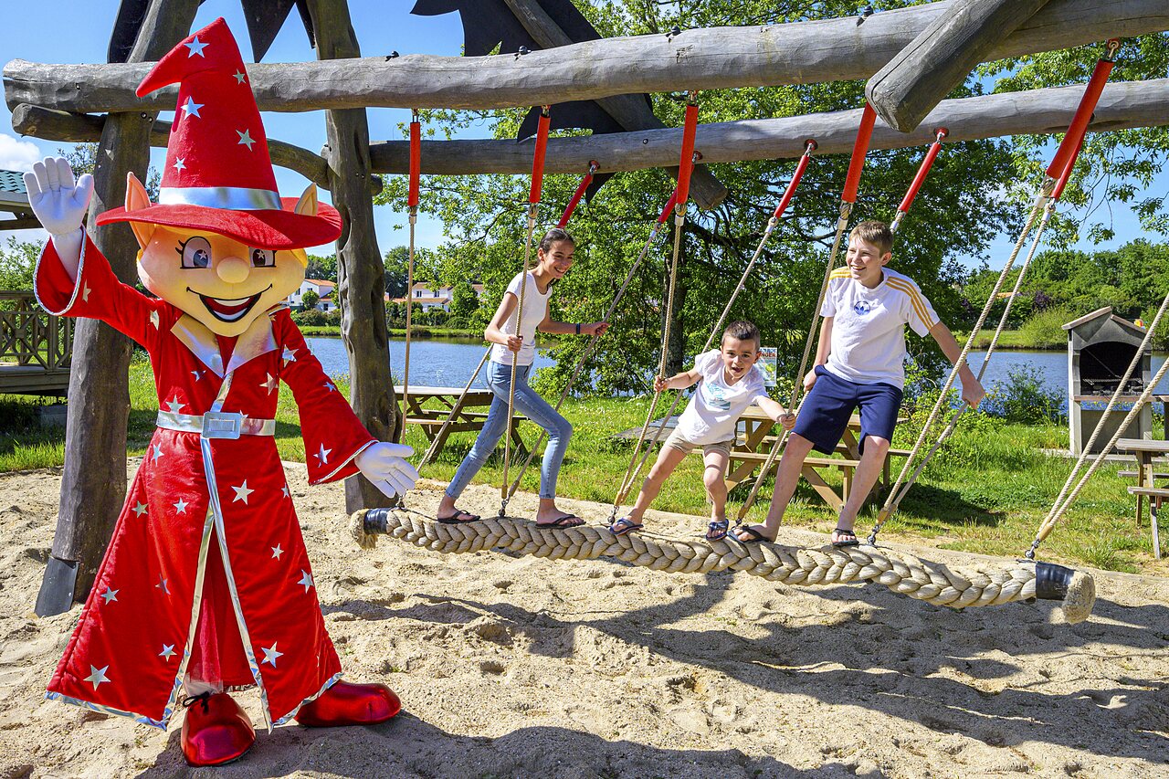 Mascotte en kinderen spelen op touwbrug op camping CAPFUN Forges in Avrille (85).