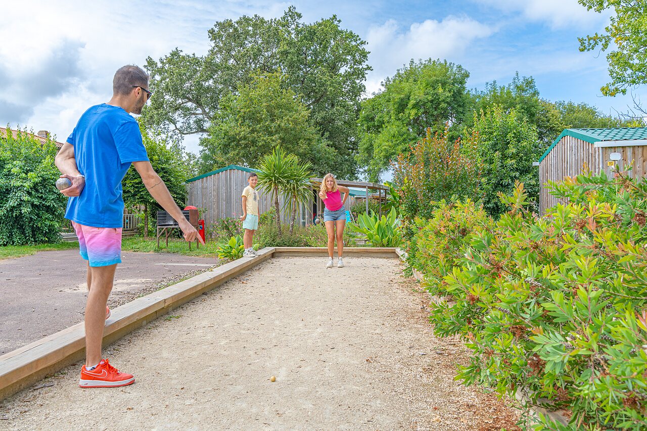 Familie speelt jeu de boules op een speciale baan op camping CAPFUN Forges in Avrille (85).