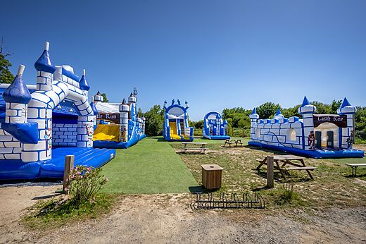 Opblaasbaar speelpark met kastelen en glijbanen op camping CAPFUN Forges in Avrille (85).