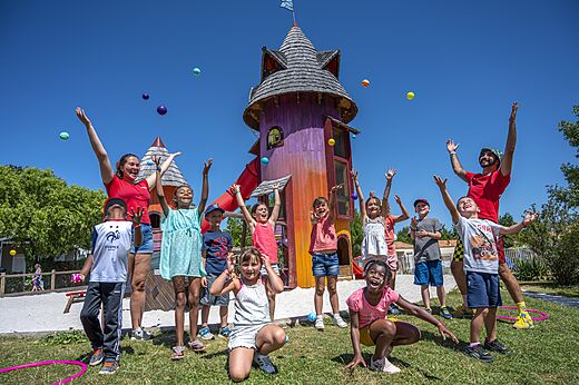 Vrolijke kinderen spelen met animators bij speeltoren op camping CAPFUN Forges in Avrille (85).