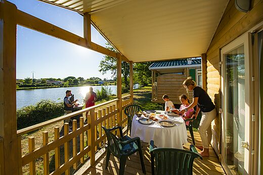 Terras van stacaravan, familie luncht, barbecue aan het meer op camping CAPFUN Forges in Avrille (85).
