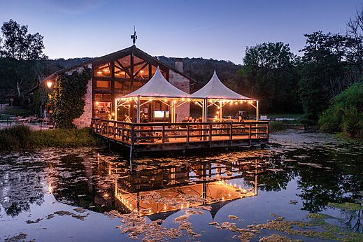 Restaurant-bar met verlicht terras aan het water op camping CLICOCHIC Forge Sainte Marie.