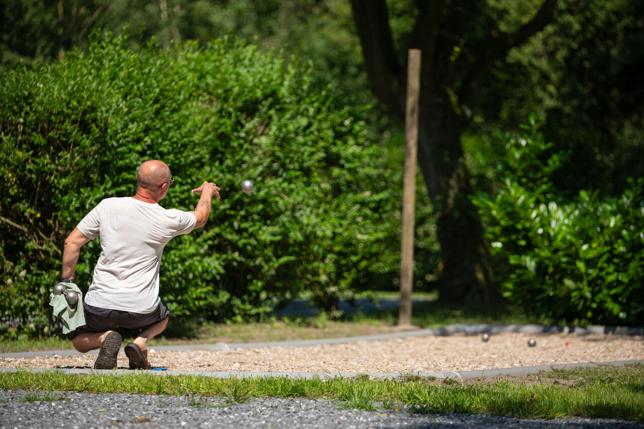 Man speelt jeu de boules op een petanquebaan op camping CAPFUN Fort Bedmar in Sint-Gillis-Waas.