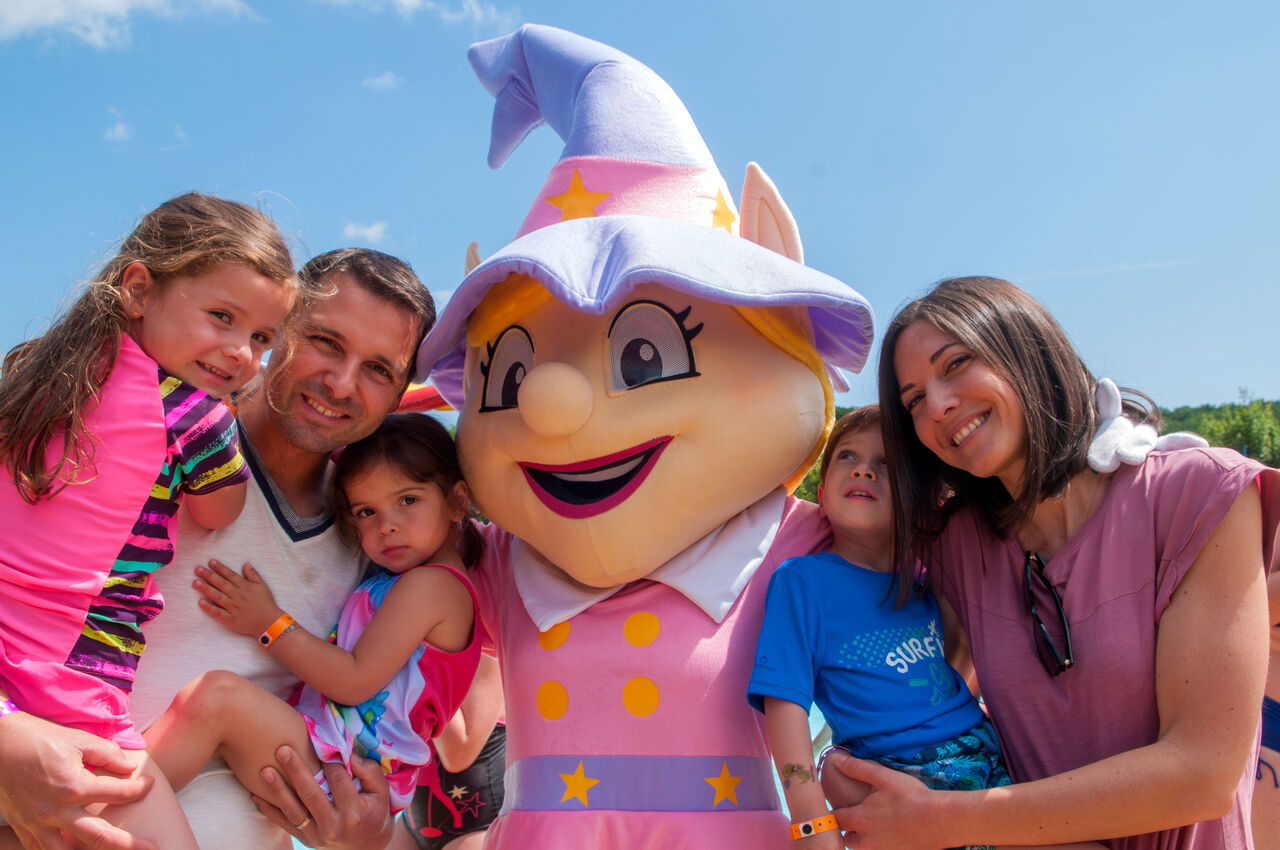 Lachende familie en mascotte op camping CAPFUN Fort Bedmar, Sint-Gillis-Waas.