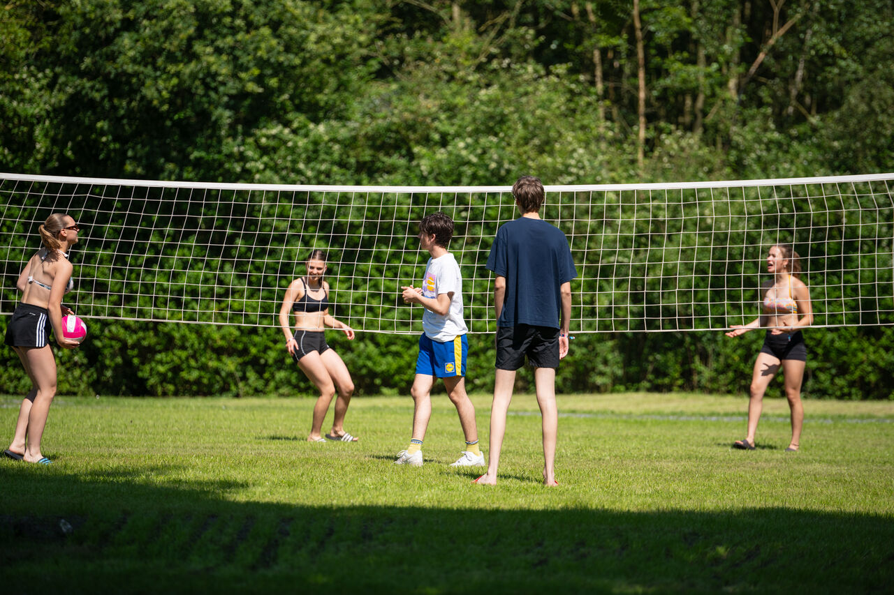 Jongeren volleyballen op buitenterrein op camping CAPFUN Fort Bedmar in Sint-Gillis-Waas.