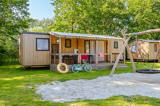 Houten stacaravan, terras, schommel op camping CAPFUN Fort Bedmar in Sint-Gillis-Waas.