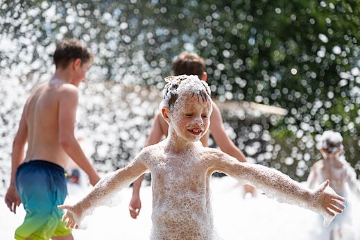Vrolijke kinderen spelen in schuim tijdens animatie op camping CAPFUN Fort Bedmar in Sint-Gillis-Waas.