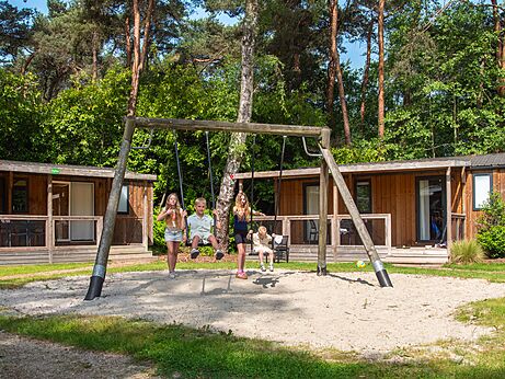 Schommel met kinderen en stacaravans op camping CAPFUN Fort Bedmar in Sint-Gillis-Waas.