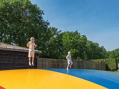 Twee kinderen springen op een reusachtig springkussen op camping CAPFUN Fort Bedmar in Sint-Gillis-Waas.