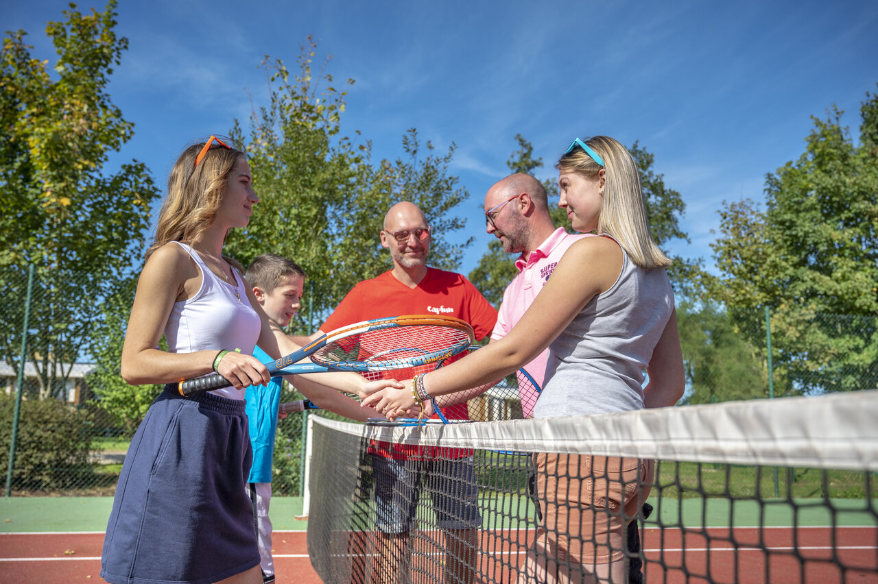 Familie en animatoren tennissen op camping CAPFUN Fort Falabraque in Seltz.