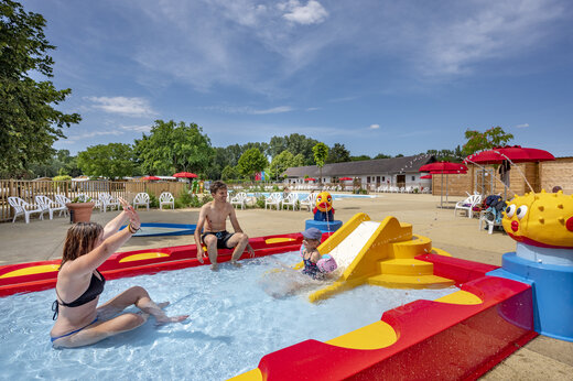 Waterspeeltuin met glijbaan en familie op camping CAPFUN Fort Falabraque in Seltz (67).