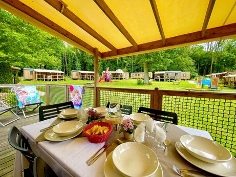 Stacaravan met terras, gedekte tafel en kinderspelen op camping CAPFUN Fredland in Tournan en Brie.