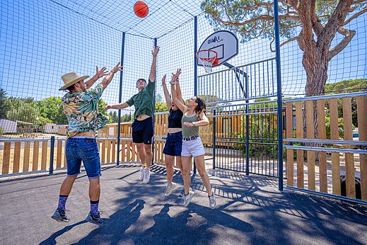 Jongeren basketballen op het multisportterrein van camping CAPFUN Le Fréjus (83).