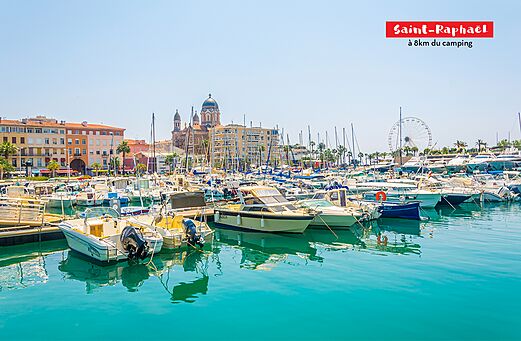 Jachthaven van Saint-Raphaël met boten, kerk en reuzenrad.