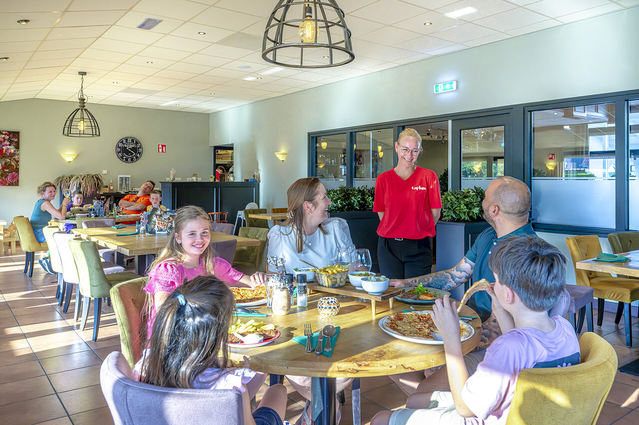 Familie dineert in het restaurant van camping CAPFUN De Fruithof in Klijndijk.