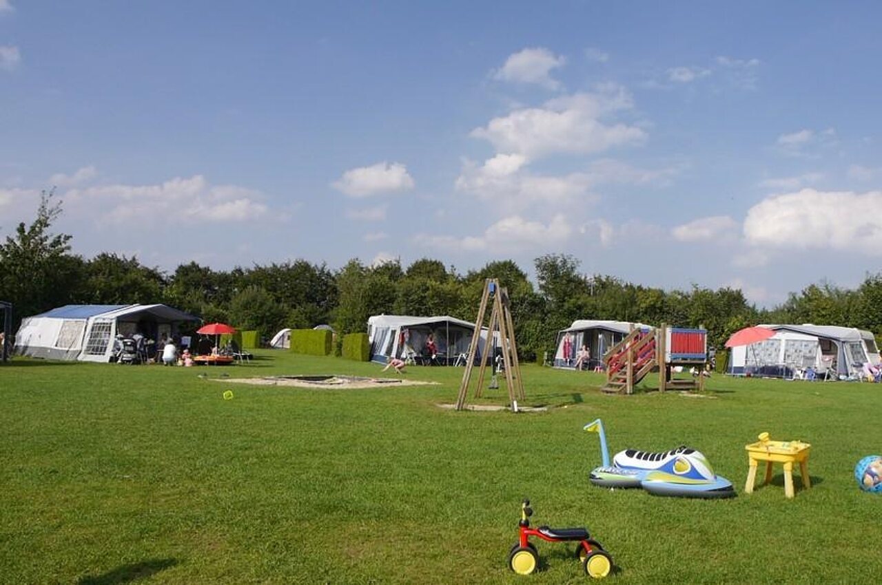 Groene kampeerplaatsen met kinderspeeltuin op camping CAPFUN De Fruithof in Klijndijk.