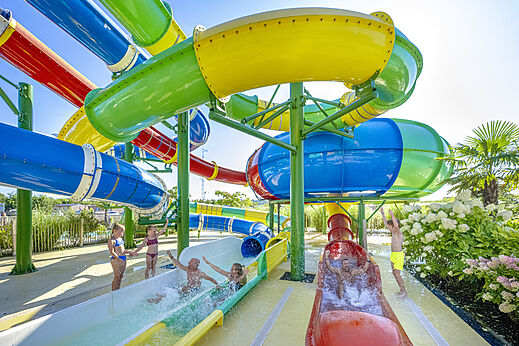 Grote kleurrijke waterglijbanen met kinderen op camping CAPFUN De Fruithof in Klijndijk.