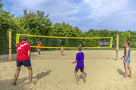 Zandstrandvolleybalveld met spelers op camping CAPFUN De Fruithof in Klijndijk.