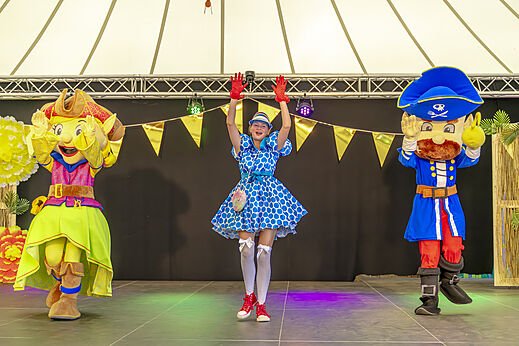 Mascottefiguren en animatrice op podium voor show op camping CAPFUN De Fruithof in Klijndijk.
