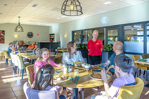 Familie geniet van diner in het restaurant van camping CAPFUN De Fruithof in Klijndijk.